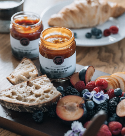 Confiture de baies d’argousier sur une planche avec pain et fruits