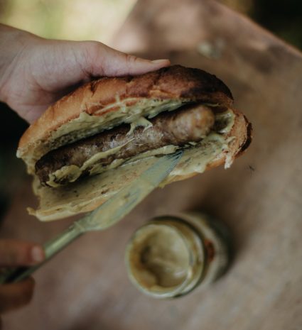 Sandwich garni de moutarde aux champignons sauvages au-dessus d’un pot ouvert
