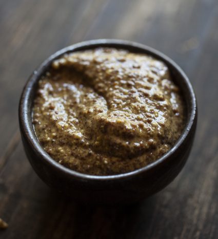 Moutarde sauvage au vin dans un petit bol sur une planche de bois