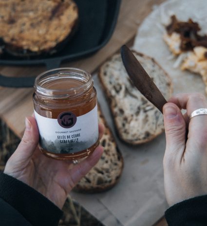 Pot ouvert de gelée de cèdre près de tranches de pain