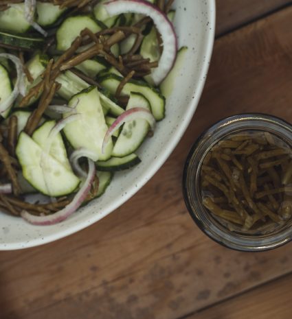 Pot de salicorne marinée près d’une salade dans un bol