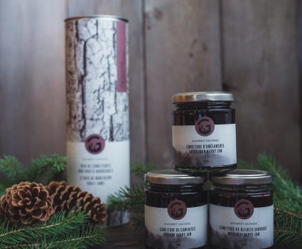 Pots de confiture sur une surface en bois avec des branches de sapin