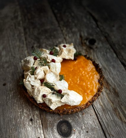 Tarte aux baies d’argousier et meringue au sapin sur des planches de bois