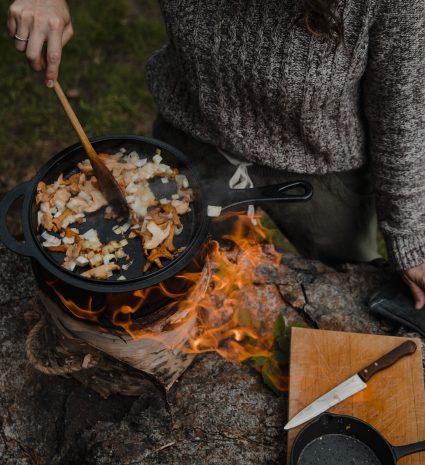 Champignons sauvages remués dans une poêle au-dessus d’un feu de bois