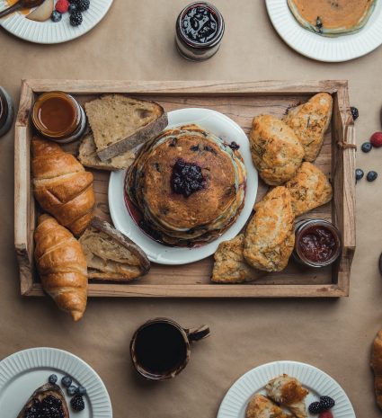 Pancakes garnis de petits fruits sur un plateau en bois