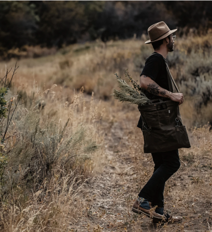 Homme marchant sur un sentier avec un sac de cueillette