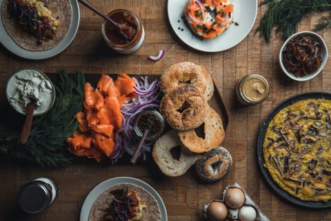 assortiment de plats avec bagels, saumon fumé et œufs sur table en bois