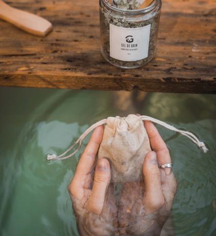 Pot de sel de bain et sachet de tissu tenu dans l’eau