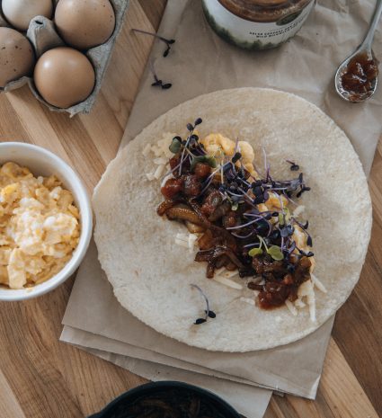 Tortilla garnie de salsa sauvage aux asclépiades sur une table en bois