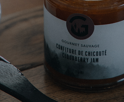 Confiture de chicouté avec des fruits et un couteau à tartiner sur une table