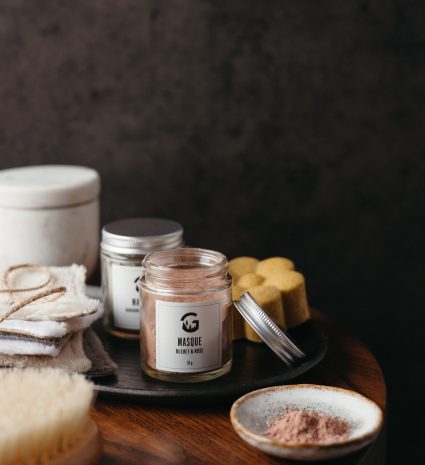 Pot ouvert de masque bleuet et rose sauvage sur une table en bois