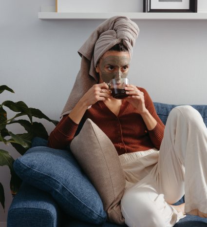 Personne avec un masque facial sur un canapé bleu