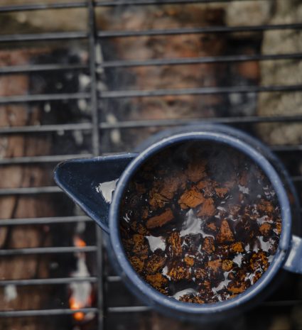 Morceaux de chaga dans une casserole sur une grille au-dessus du feu