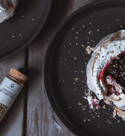 Flacon de poudre de mélilot près d’une meringue garnie de crème