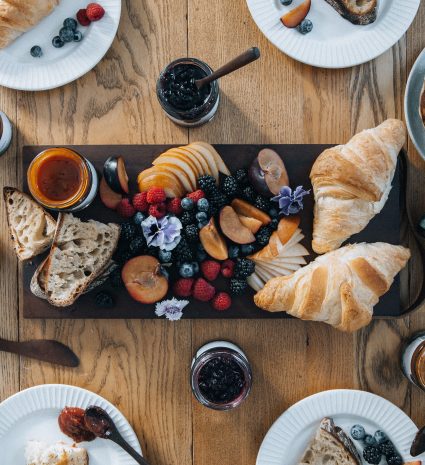Preserves, wild blueberries and pastries on a wooden table