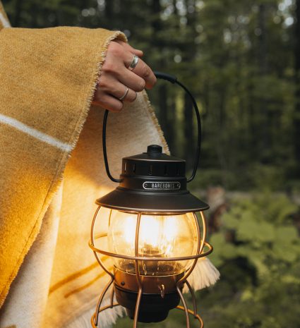 Lanterne rechargeable en métal noir dans une forêt