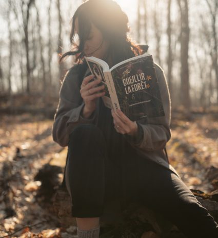 Personne lisant le livre Cueillir la forêt dans une forêt