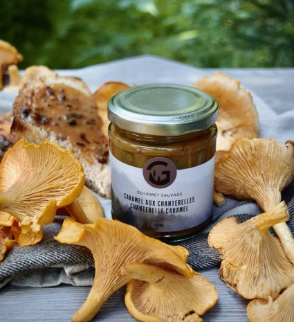 Pot de caramel aux chanterelles entouré de champignons sur une table