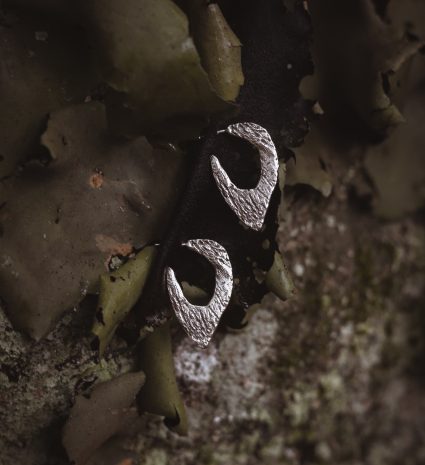 Boucles d’oreilles Lichen posées parmi les lichens sur une surface rugueuse