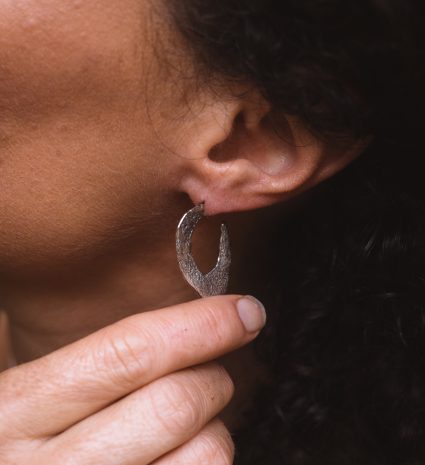 Boucle d'oreille en forme de lichen près d'une oreille