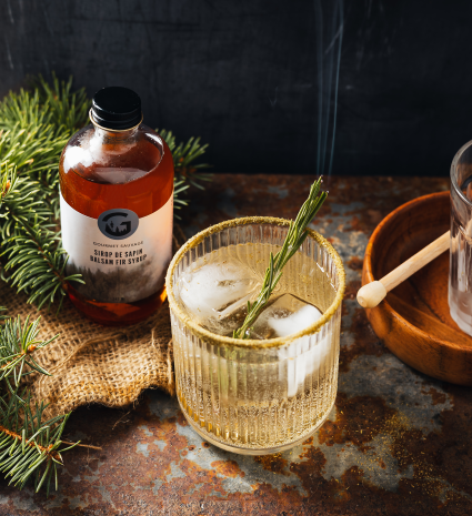 Sirop de sapin artisanal et verre glacé sur une table rustique