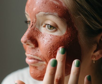 Femme avec un masque de beauté rouge sur le visage