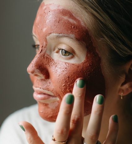 Femme avec un masque de beauté rouge sur le visage