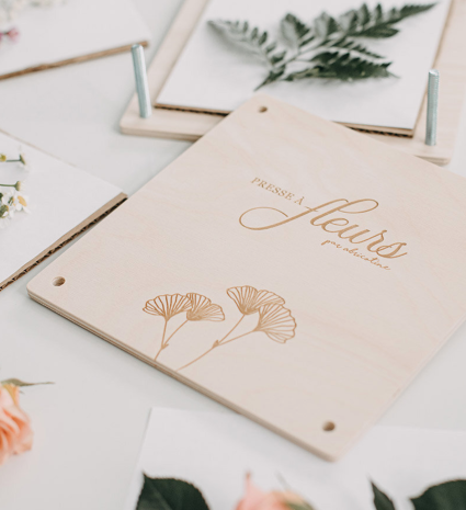 Presse à fleurs en bois avec une fougère et des fleurs autour