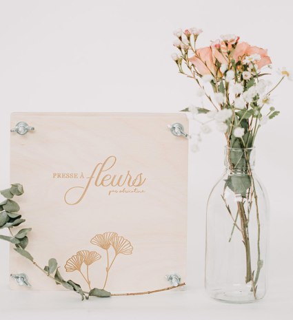 Presse à fleurs en bois près d’un vase de fleurs