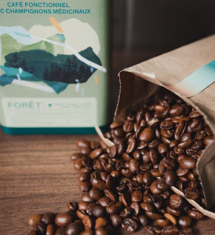 Sac de café fonctionnel aux champignons médicinaux avec grains de café sur table en bois