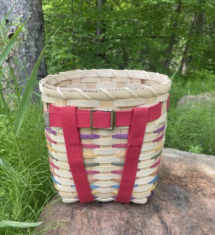 Sac à dos de cueillette tressé posé sur un rocher en forêt
