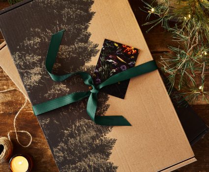 Coffret gourmand aux conifères sur une table en bois