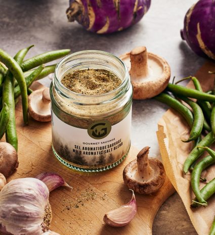 Pot de sel aromatique sauvage sur une planche avec ail et champignons
