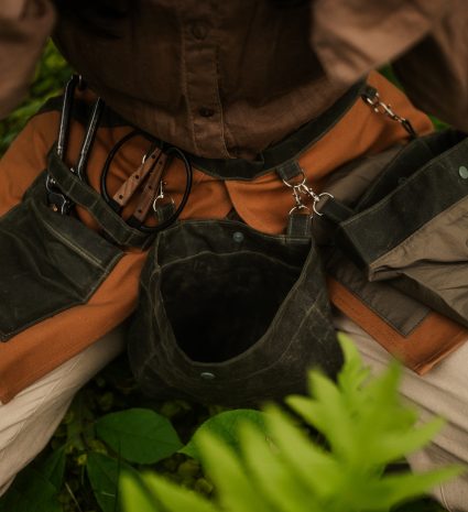 Tablier de cueillette avec poches et outils parmi les plantes forestières