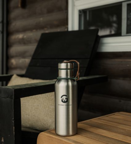 Gourde isotherme en acier posée sur une table en bois