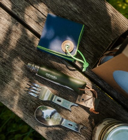 Ensemble de camping avec couteau, fourchette et cuillère sur planche de bois