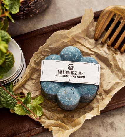 Shampooing solide bleu pour cheveux frisés sur du papier froissé
