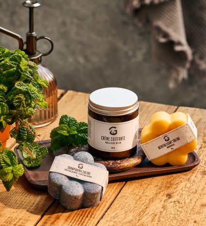 Shampooing solide, revitalisant et crème coiffante sur une table en bois