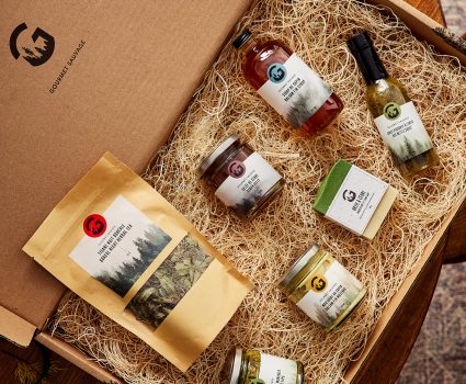 Coffret gourmand de produits aux conifères dans une boîte garnie de fibres de bois