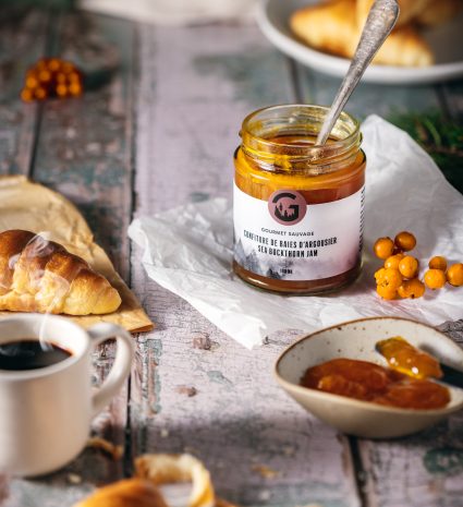 Confiture de baies d’argousier avec des croissants sur une table en bois