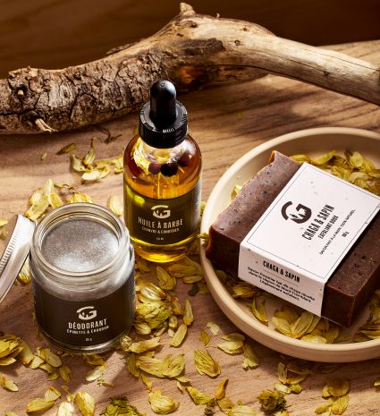 Huile à barbe, déodorant et savon chaga-sapin sur une planche de bois