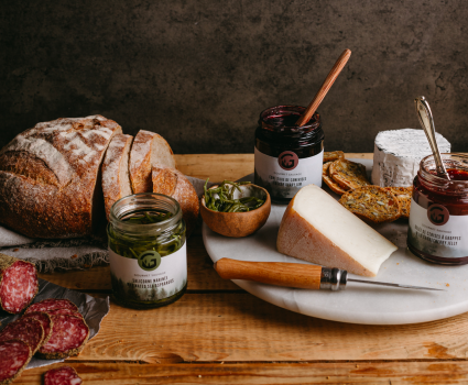 Pain de campagne, fromage et gelées sur plateau en marbre