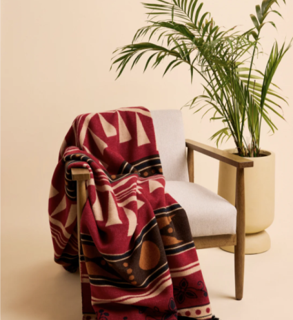 Couverture réversible Kwe – Éco sur un fauteuil à structure de bois