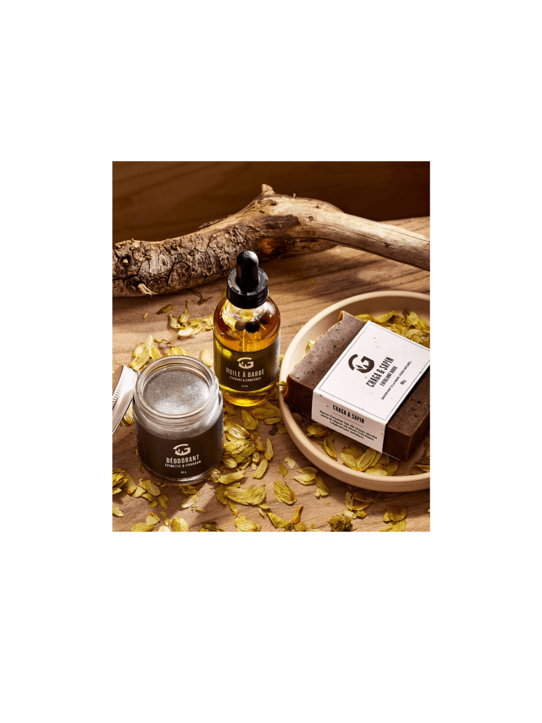 Huile à barbe, déodorant et savon chaga-sapin sur une table en bois