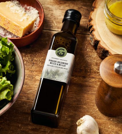 Bouteille de vinaigre balsamique au mélèze et mélilot sur une planche