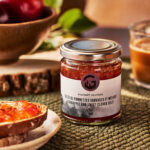 Jar of wild crabapple and sweet clover jelly on a table with bread