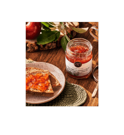 Jar of wild crabapple jelly with toast on a wooden table