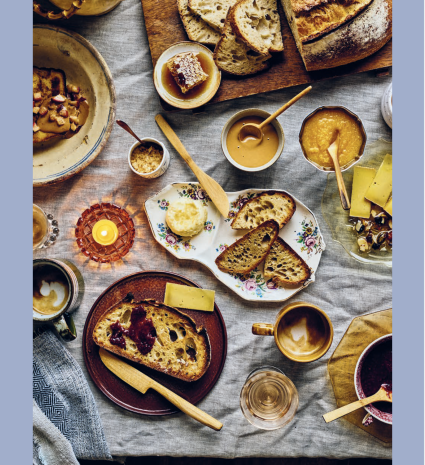 Pain au levain, miel et tartinades disposés sur une table de brunch