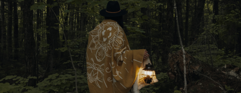 Femme avec une lanterne dans une forêt
