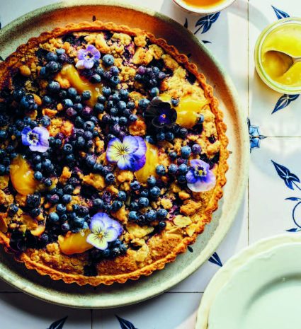 Tarte aux bleuets et fleurs violettes sur une assiette